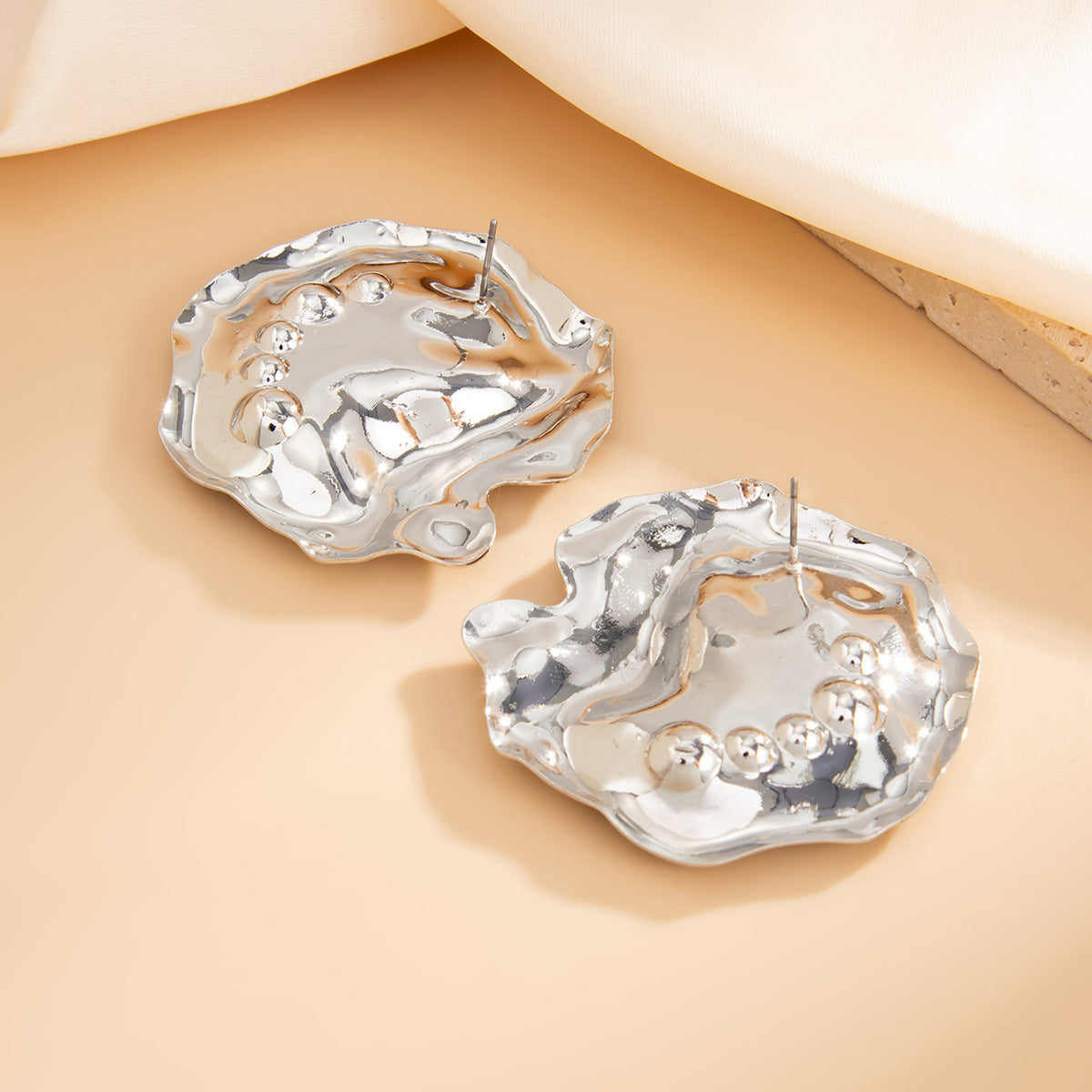 Fashion Metal Texture Glossy Earrings showcasing pleated irregular geometry design with a shiny silver finish.